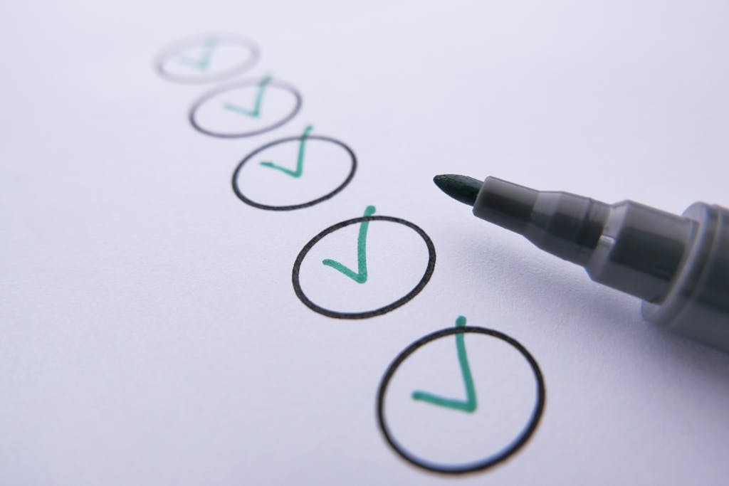 Photo by Towfiqu barbhuiya Close-up of a checklist with green checkmarks on white paper using a marker.